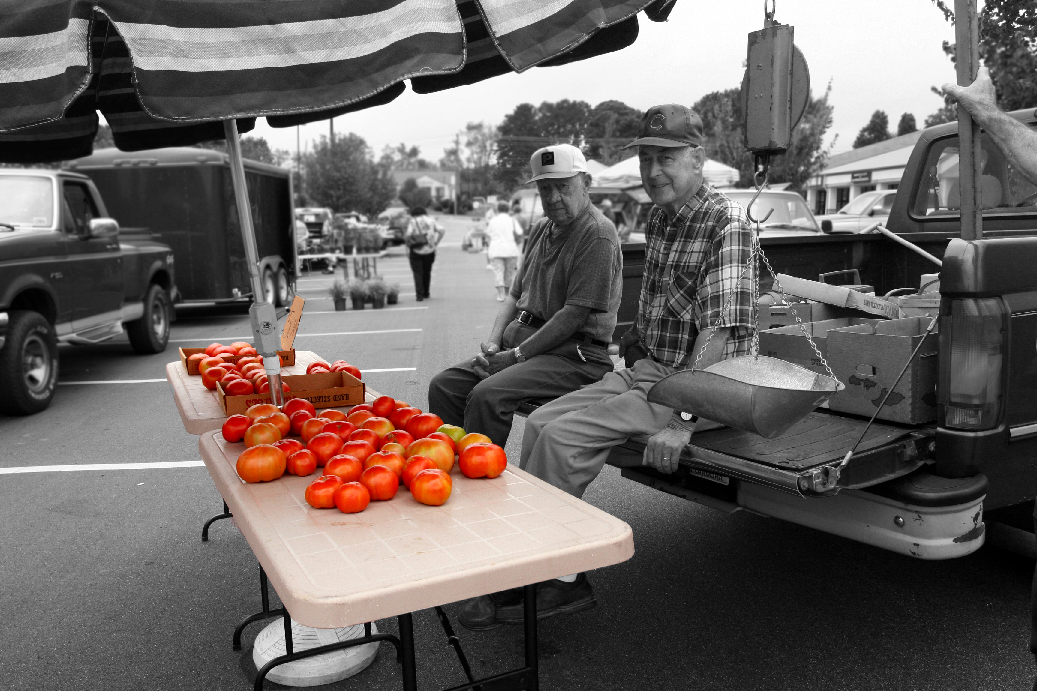Farmer sits in front of tomatoes at Famer Market